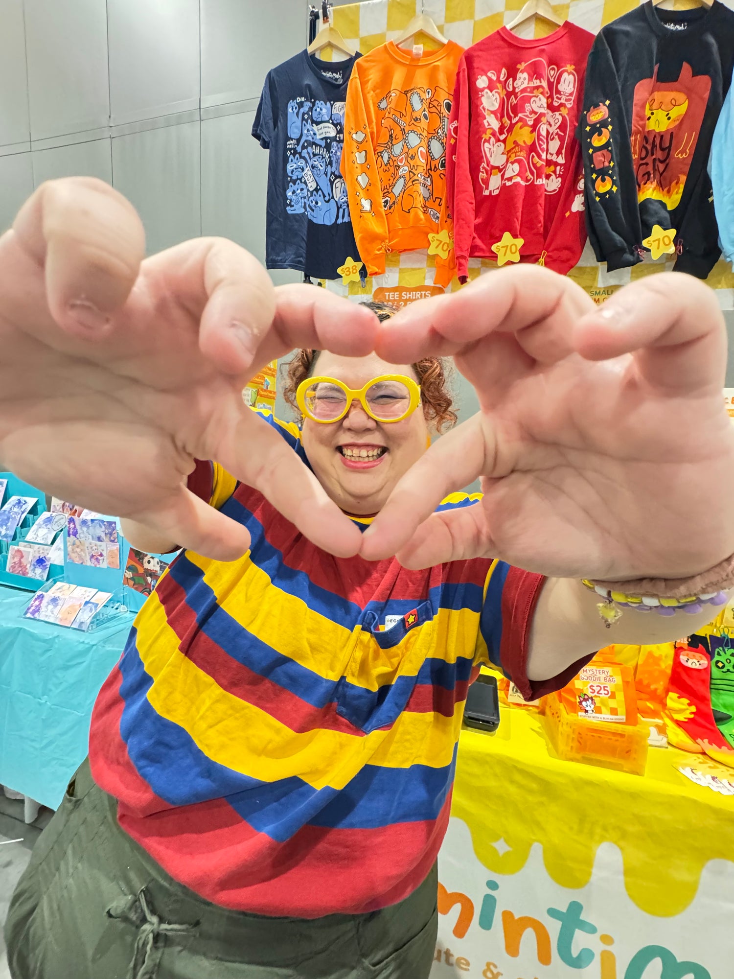 Mel, the owner of Mintimeli, signing a heart to the camera with their hands.